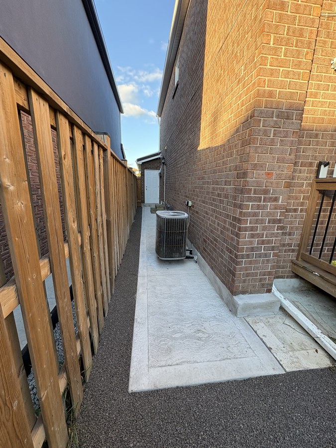 Concrete side walkway beside a brick home