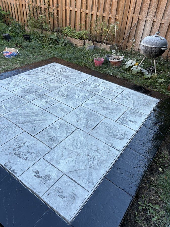 Stamped concrete patio laid in a backyard